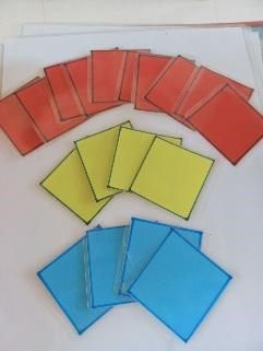 Laminated red, yellow and blue cards laid out in a fan shape for a classroom activity