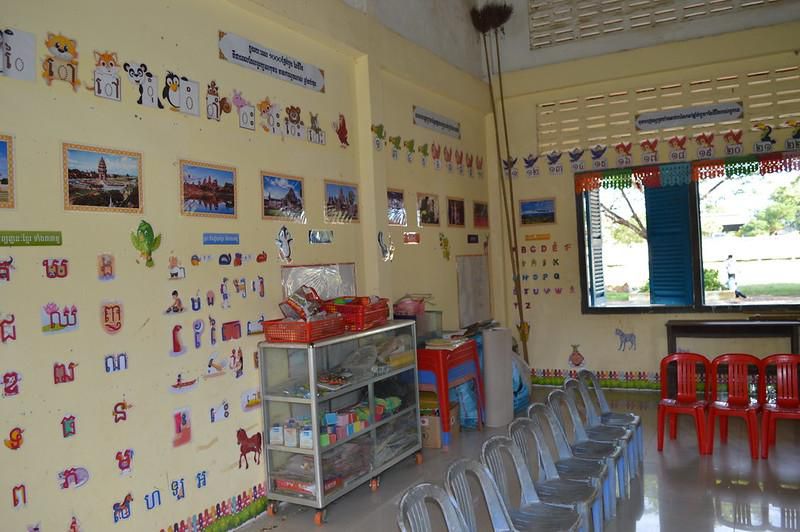 A preschool classroom with colorful alphabet cards and picture displays on the walls and a shelf of learning materials