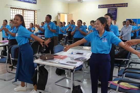 Teachers stand and move along to a song activity during the first workshop