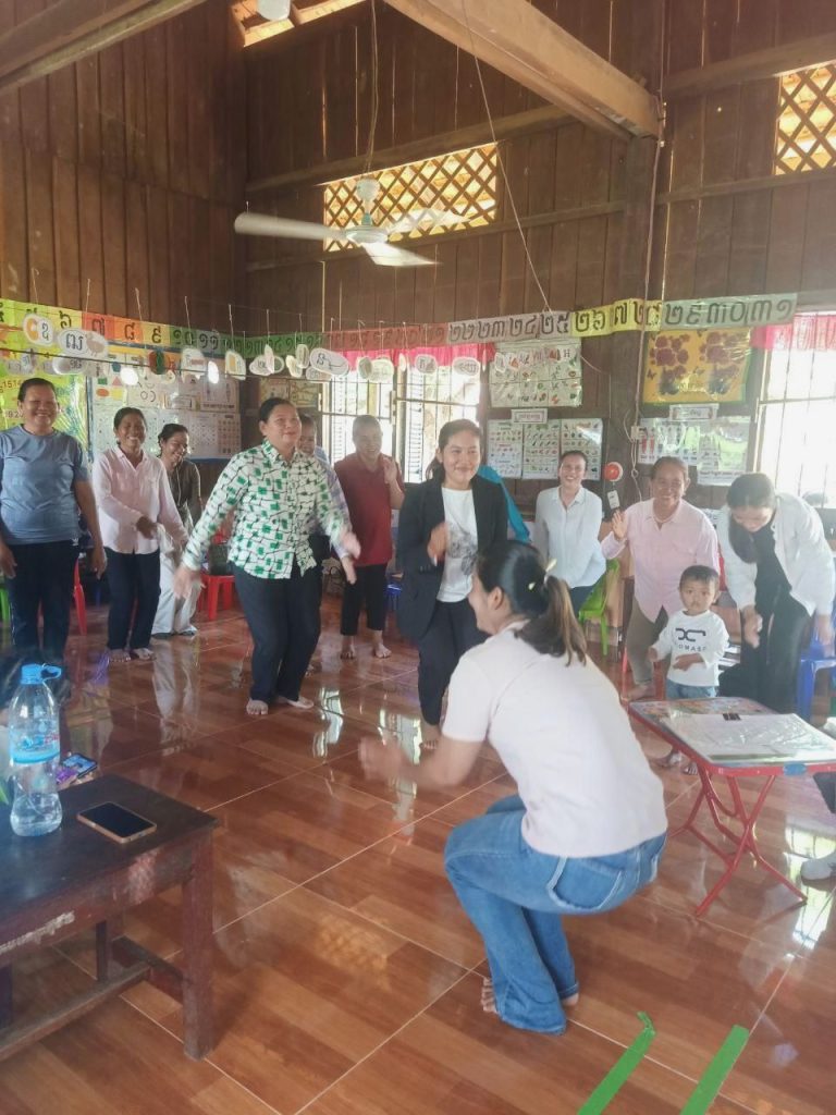 Teachers and education officials gather in a wooden classroom hall during the technical meeting