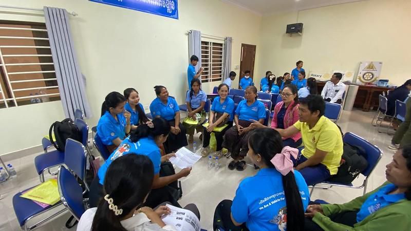 Teachers in blue shirts hold discussion papers during a group work session at the annual meeting