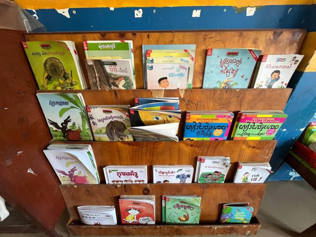 Preschool storybooks displayed on a wooden bookshelf in a classroom
