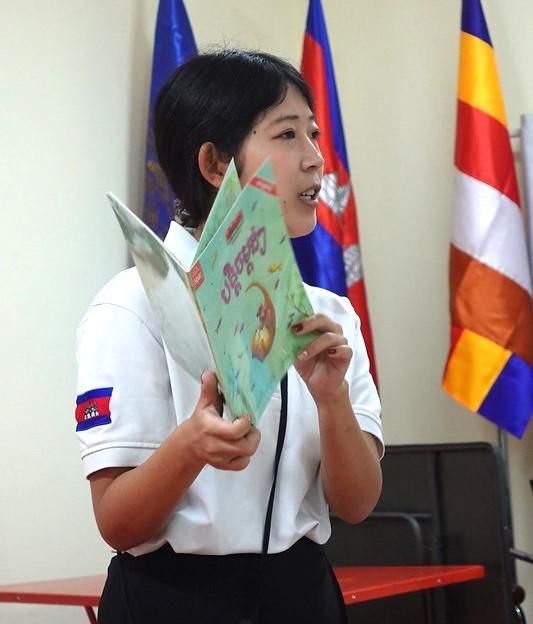 A second JICA volunteer holds up a picture book during her session at the workshop