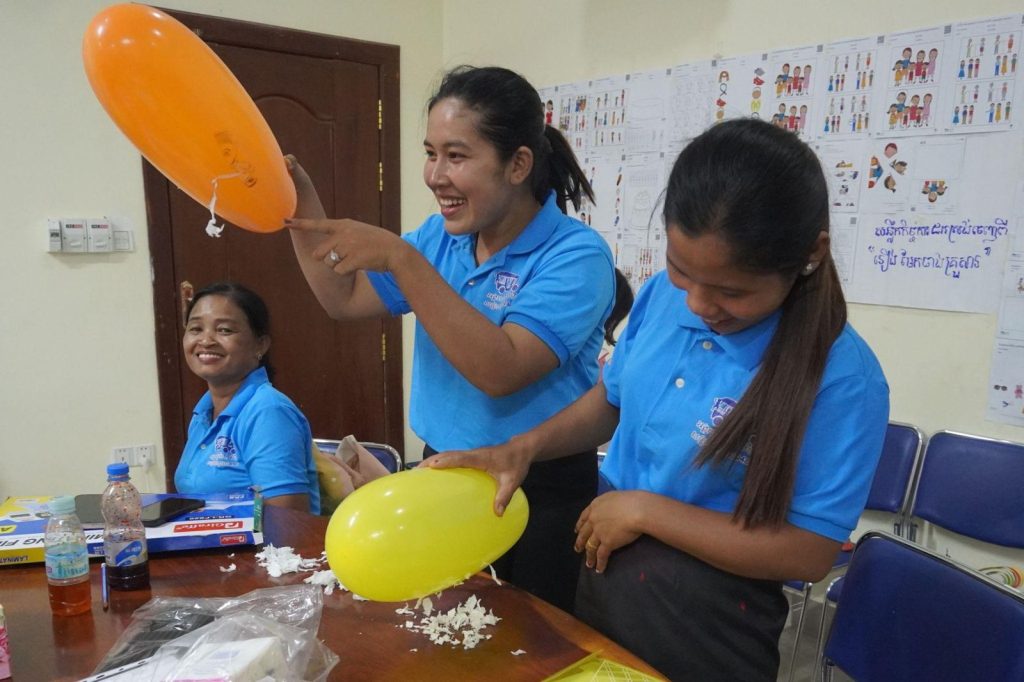 Teachers rub inflated balloons to try the static electricity experiment at the workshop