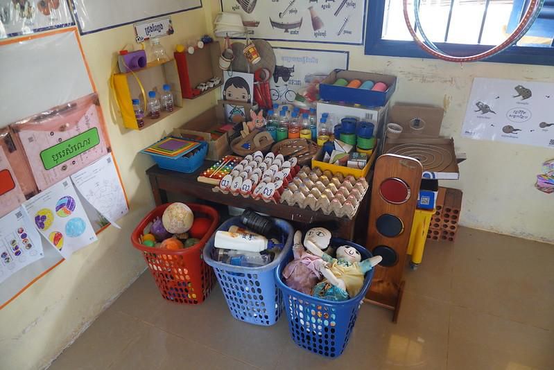 Baskets of toys and craft materials arranged on a table in a classroom corner