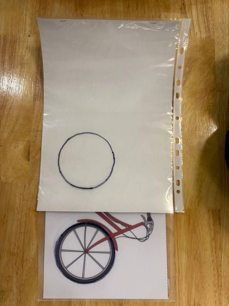 A new activity sheet showing a drawn circle on a clear sleeve placed over a bicycle picture