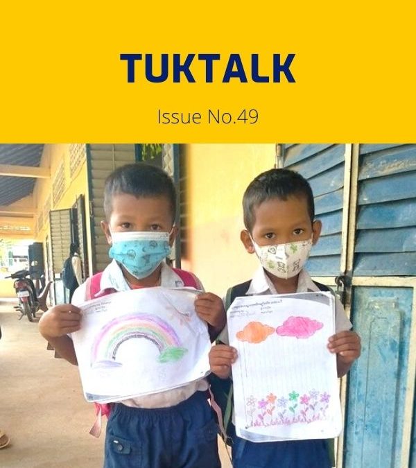 Two children in face masks hold up their drawings of a rainbow and flowers