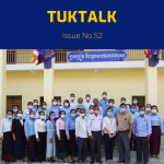 TukTuk staff, teachers and education officials pose in front of a school building
