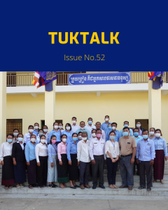 TukTuk staff, teachers and education officials pose in front of a school building