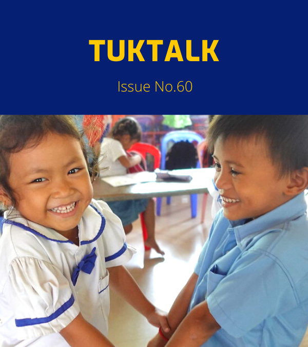 Two smiling kindergarten children in school uniform hold hands