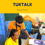 TukTalk 67 cover: a TukTuk staff member works at a laptop at a desk while a colleague looks on