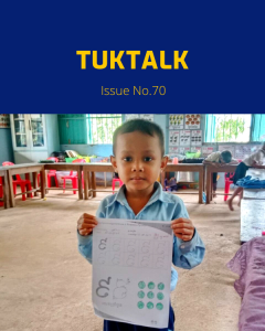 TukTalk 70 cover: a preschool boy holds up a Khmer letter worksheet in his classroom
