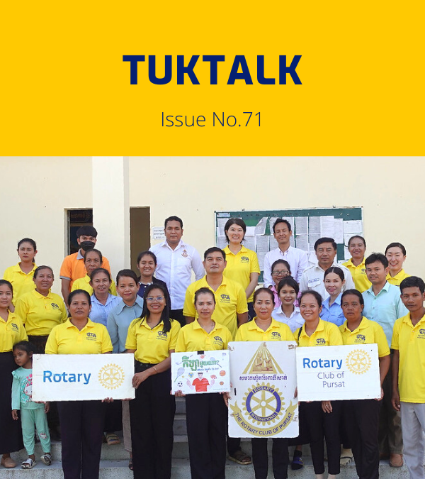 Workshop participants and TukTuk staff in yellow shirts hold Rotary Club of Pursat signs for a group photo