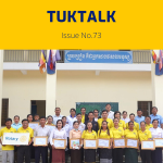 TukTalk 73 cover: teachers, officials and TukTuk staff hold framed certificates in front of a school building