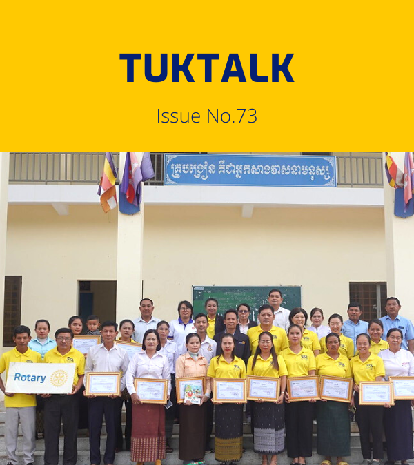 TukTalk 73 cover: teachers, officials and TukTuk staff hold framed certificates in front of a school building