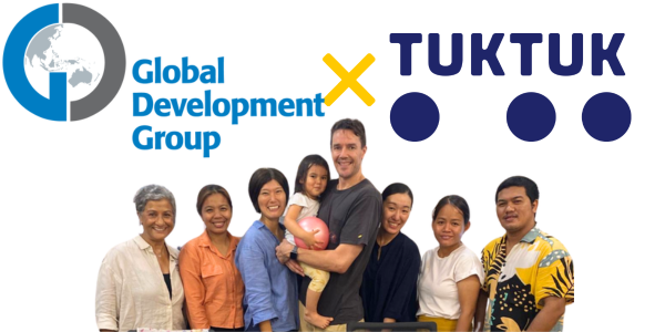 Global Development Group and TukTuk logos above a group photo of GDG visitors, TukTuk staff and a toddler