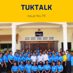 TukTalk 79 cover: dozens of teachers and officials in blue polo shirts pose in rows in front of a building
