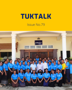 TukTalk 79 cover: dozens of teachers and officials in blue polo shirts pose in rows in front of a building