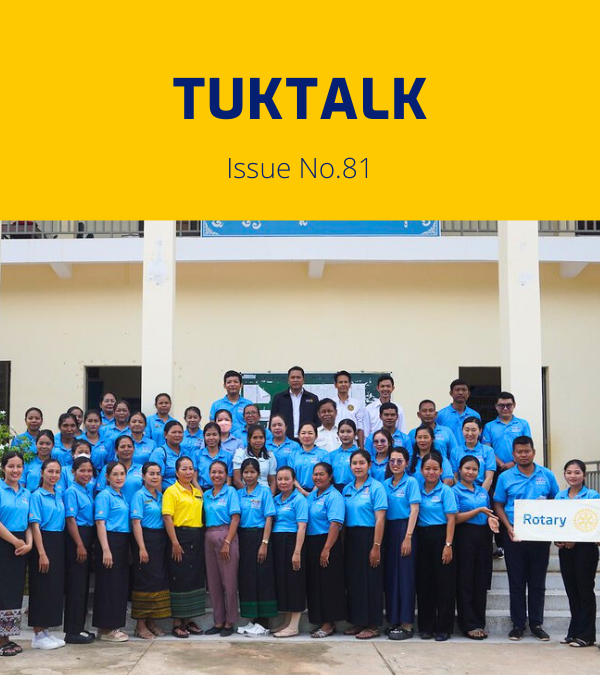 TukTalk 81 cover: dozens of teachers in blue polo shirts pose outside a building with a Rotary sign