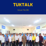 TukTalk issue 86 cover: officials, teachers and TukTuk staff pose together in a meeting hall after the CLIP3 annual meeting