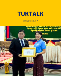 TukTalk issue 87 cover: a TukTuk staff member holds a certificate beside an official on stage at the provincial conference