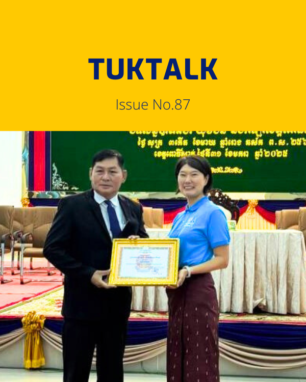 TukTalk issue 87 cover: a TukTuk staff member holds a certificate beside an official on stage at the provincial conference