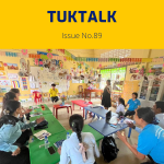 TukTalk issue 89 cover: teachers and TukTuk staff talk around green tables in a colourful classroom