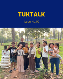 TukTuk staff and family members pose together among pine trees on the staff trip