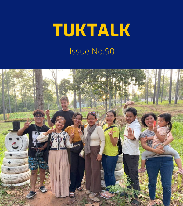 TukTuk staff and family members pose together among pine trees on the staff trip