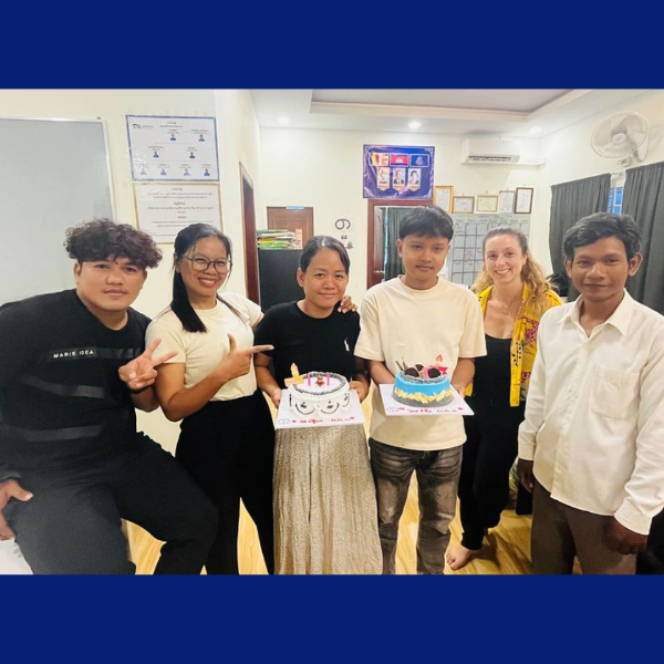 TukTuk staff and a volunteer pose with two birthday cakes in the office