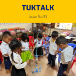 Preschool children play with sticks, string and water bottles in a classroom activity