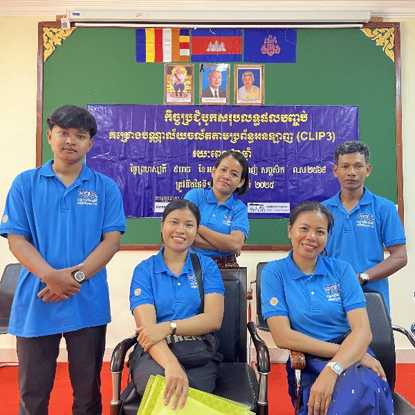 TukTuk staff in blue shirts pose together in front of the CLIP3 closing meeting banner