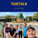 TukTalk issue 98 cover above a selfie of TukTuk staff and friends posing beside a roundabout monument