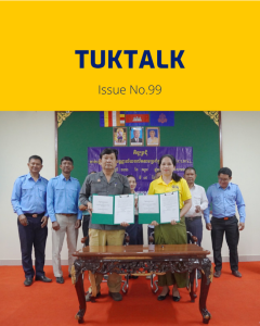 TukTalk issue 99 cover above a photo of officials and TukTuk staff holding signed agreement folders at a table